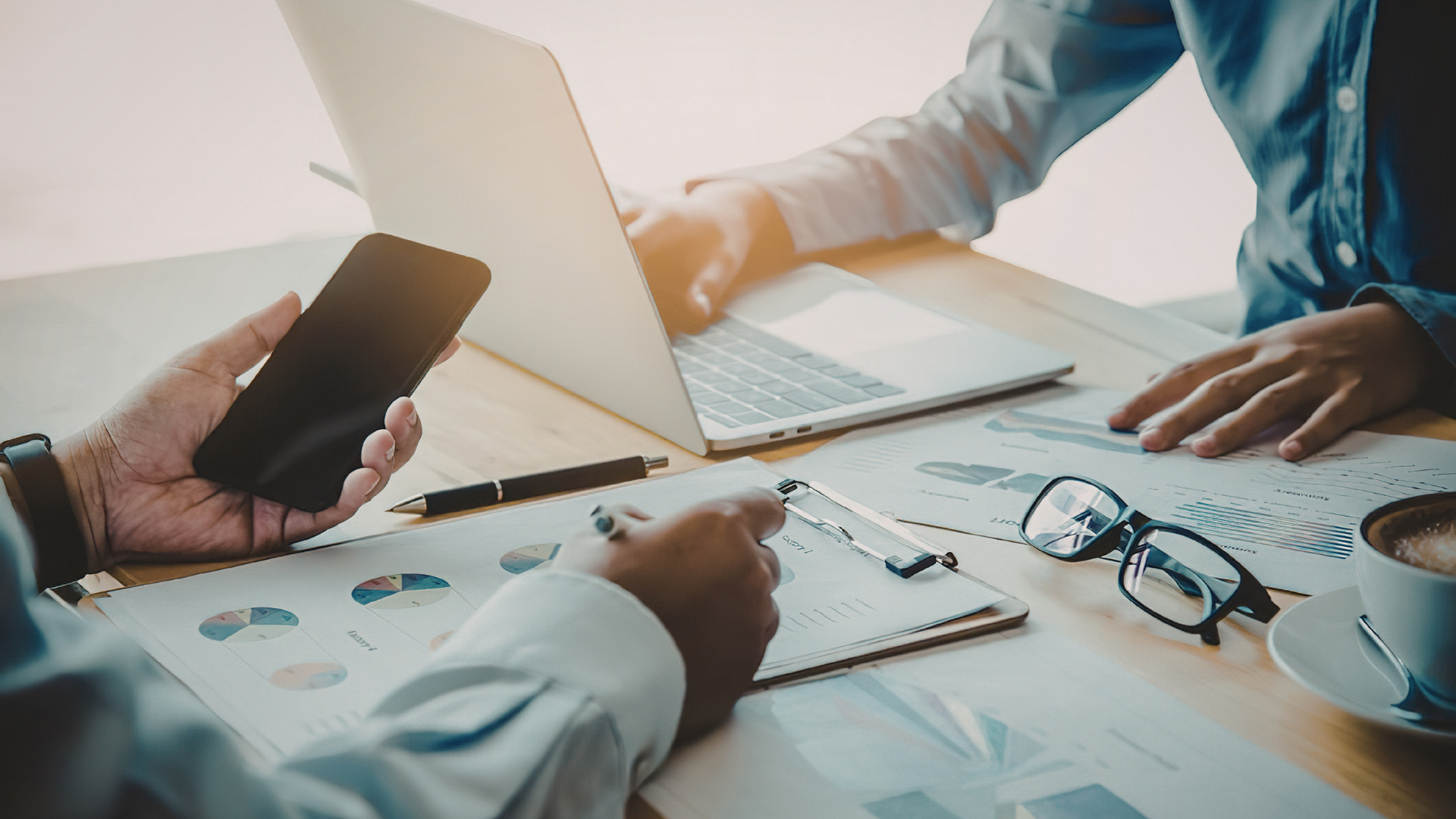 Financial due diligence review with M&A advisors analyzing EBITDA, cash flow, and business performance data during a business sale